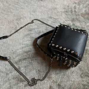 Zara väska med nitar - Säljer den populära och coola nitväskan från Zara. Väskan har två innerfack och en lång kedja till som man kan ha crossbody. 