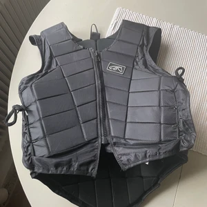 Ridväst - Tror märket heter Riders Company, är inte så insatt.  Använt några gånger för några år sen, fungerar som vanligt.  Passade mig som liten och än nu, är 166cm och väger 49kg. 