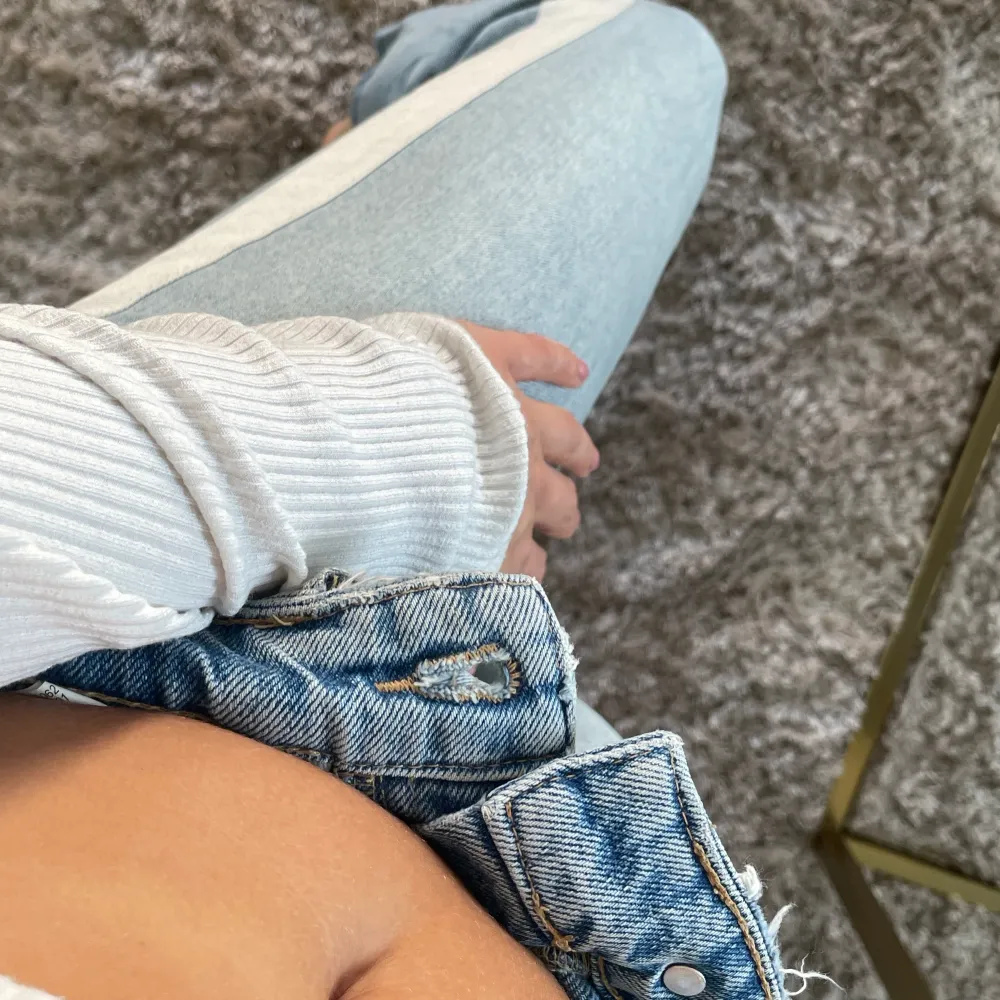 Ett par snygga ljusblå jeans från zara med ett vitt band som går längs sidorna. Byxorna är ankellånga och är  avklippta nertill. Aningen stora i midjan men sitter snyggt över rumpan ;) . Jeans & Byxor.