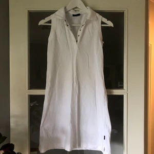 Vit pikéklänning - Vit pikéklänning i sportig modell från märket L.O.G.G Sport. Behövs strykas. 