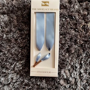 Skosnöre - Ljusblåa skosnören i siden med guldig detalj. Skriv för längd eller mer info