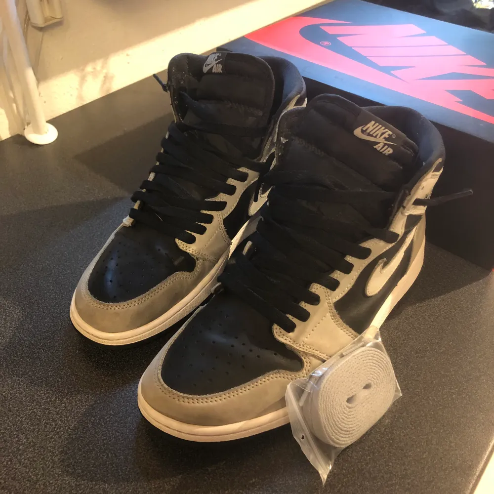 Jordan 1 i modellen shadow 2.0, storlek 44,5 Använda men i bra skick, köpta från SNS Ingår orginalbox och oanvända snören. Skor.