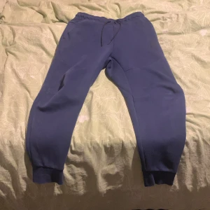 Blå Nike tech fleece byxor - Säljer mina tech fleece byxor pga att dem är förstora och det är bra skick. Det ända är att färgen har bleknat lite. Storlek M