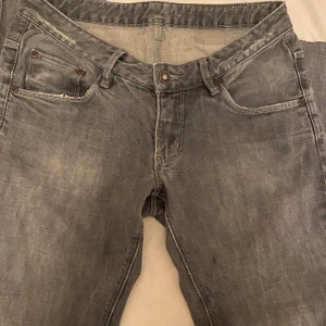 Gråa lågmidjade jeans  - Säljer dessa as snygga gråa lågmidjade jeansen som jag köpt secondhand i sommars men som aldrig passat mig, står tyvärr ingen storlek i men skulle säga ungefär Xs/s. De har en slits i slutet av benen och några hål (som ska vara där)❤️ skriv för fler bilder eller frågor❤️