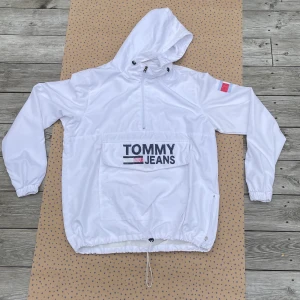 Tommy Hilfiger Wind Breaker Jacka - Clean windbreaker i vitt från Tommy Hilfiger. Storlek Large och passar likadant. Osäker på hur gammal den är men är 8/10 kanske till och med 9/10 när det kommer till dess skick. OBS! Har inte ficka där framme utan bara plats för händerna. Ha det bäst💯💯