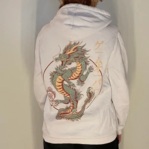 Hoodie - Vit huvtröjor med framficka och tyck i ryggen.