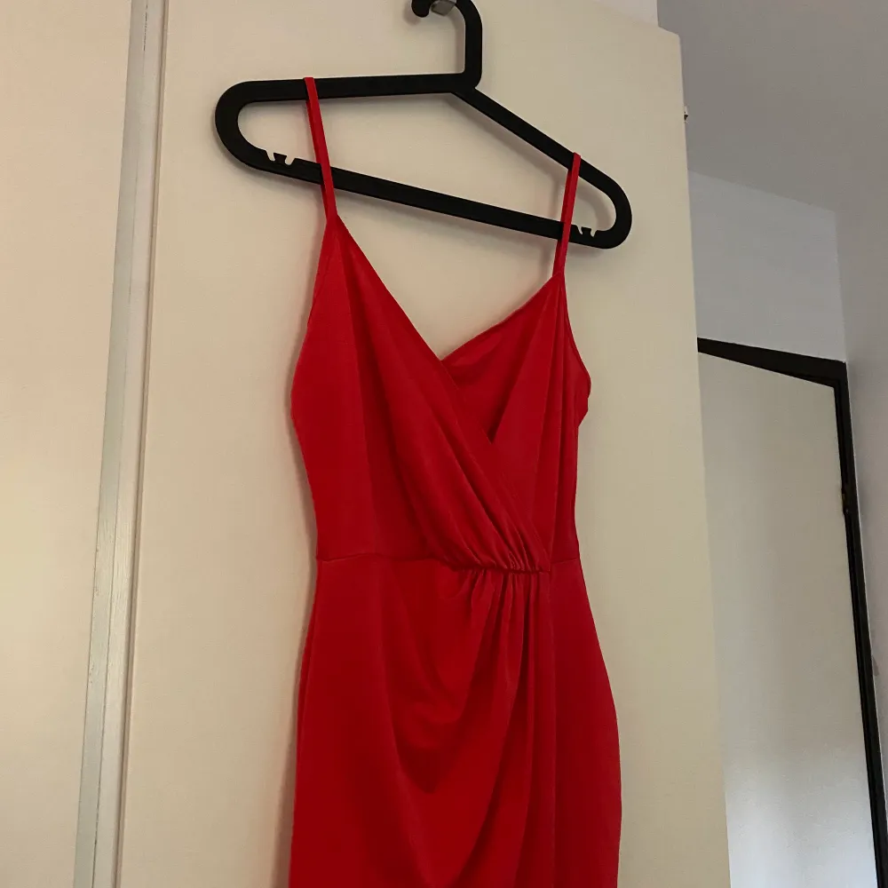 En elegant fin röd klänning från Nelly. Enbart använd 1 gång. Sitter jättefint på kroppen och ger en fin figur. . Klänningar.