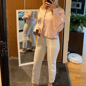 Vita jeans med slitningar längst ner vid ankeln