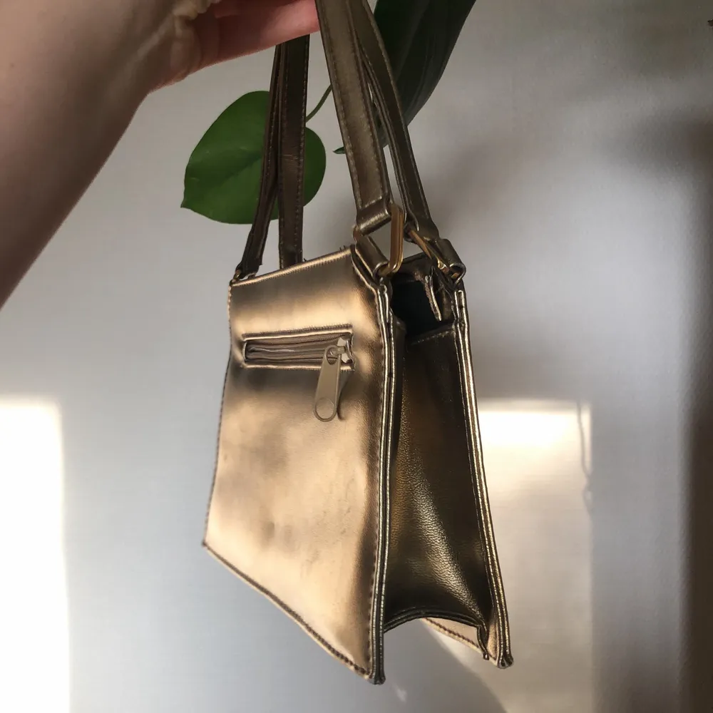 Liten handväska från Jane Shilton / Clubhouse i guld. Osäker om det är äkta läder eller ej men den känslan iaf. Dragkedja, litet fack inuti och ett på baksidan. I fint skick. . Väskor.