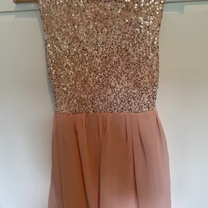 Rosa klänning - Säljer nu en fin rosa klänning med glitter på halva klänningen och rosa kjol med foder. Den är i storlek 36/38, har haft en gång på en fest så den är i väldigt fint skick. Öppen rygg med litet snöre man knyter och med dragkedja. Den önskar ett nytt hem :)