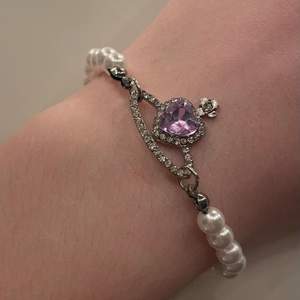 Gulligt armband med pärlor och ett lila diamant hjärta i mitten 🤍 
