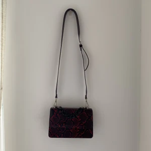 Röd handväska - Denna väska är en fin väska som jag köpte för ett år sedan ungefär denna väska han jag aldrig använt dem olika handtagen får att ta bort om man vill ta av dom eller ha ett annat handtag.🤩priset kan diskuteras!