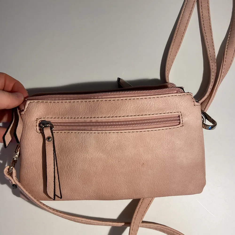 Detta är en helt oanvänd rosa handväska! Den har utöver dem två stora facken inuti, 3 mindre fack som går att stänga med dragkedja (två på ytter sidorna, och en på insidan) . Väskor.