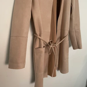 Vårkappa i mockaimitation - Beige/rosa vårkappa i mockaimitation med knytskärp från H&M, som ny. 