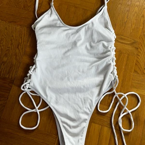 Baddräkt HM, S-M - Oanvänd baddräkt från HM. Storlek S-M. Highwaisted. Mjukt ribbat tyg med knytning i sidorna. Frakt 66 spårbart 