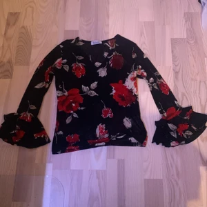 Shirt - Tröja med röda blommor, puff i ärmarna och genomskinlig så behövs kanske ett linne under. Köpt på secondhand men märket är xanaka. Köpare står för frakt och står inte för postens slarv:) OBS: katt i hemmet så kan förekomma katthår men tvättas och fixas innan frakt ‼️pris kan diskuteras ‼️