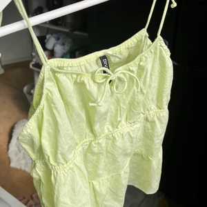 Ljus grön/gul topp - En ljusgrön/ljusgul topp från h&m använd endast en gång!! Väldigt bra skick! Passar mig som vanligtvis är 38 i toppar men skulle säga tt den passar ca 36-42 pga stretchigt tyg.
