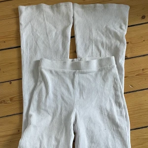 Vita Utsvängda byxor  - Utsvänga vita byxor, mjukt material. Ganska använda, men ändå fina. De är inte ribbade men med ränder typ. Köparen står för frakt. 