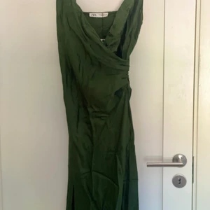 Mörkgrön satin långklänning  - En mörkgrön satinklänning som man kan klä upp och ner. Har den redan i brun och är lätt att bära på olika tillfällen. Denna är aldrig använd. Ny pris 399 Säljer för 150:- 