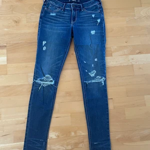 Hollister super skinny jeans  - Hollsiter jeans i passform skinny. Slitningar över knäna och lite vid låren. Storlek 3, W26. Använda cirka 7 gånger 