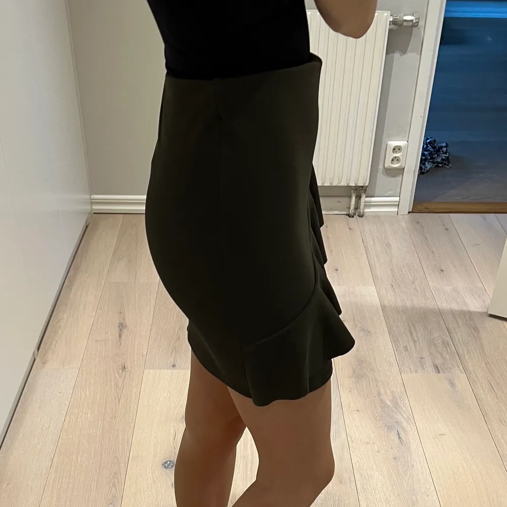 En khakigrön kjol med volang på framsidan av kjolen ifrån zara i storlek Small!💚 töjbar och jättebekväm!. Kjolar.