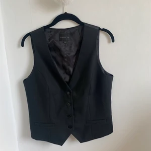 Väst - Svart väst i storlek 42 från märket STOCKH LM🖤 skulle säga att den passar någon med B/C kupa.  Fraktkostnaden kan variera💞