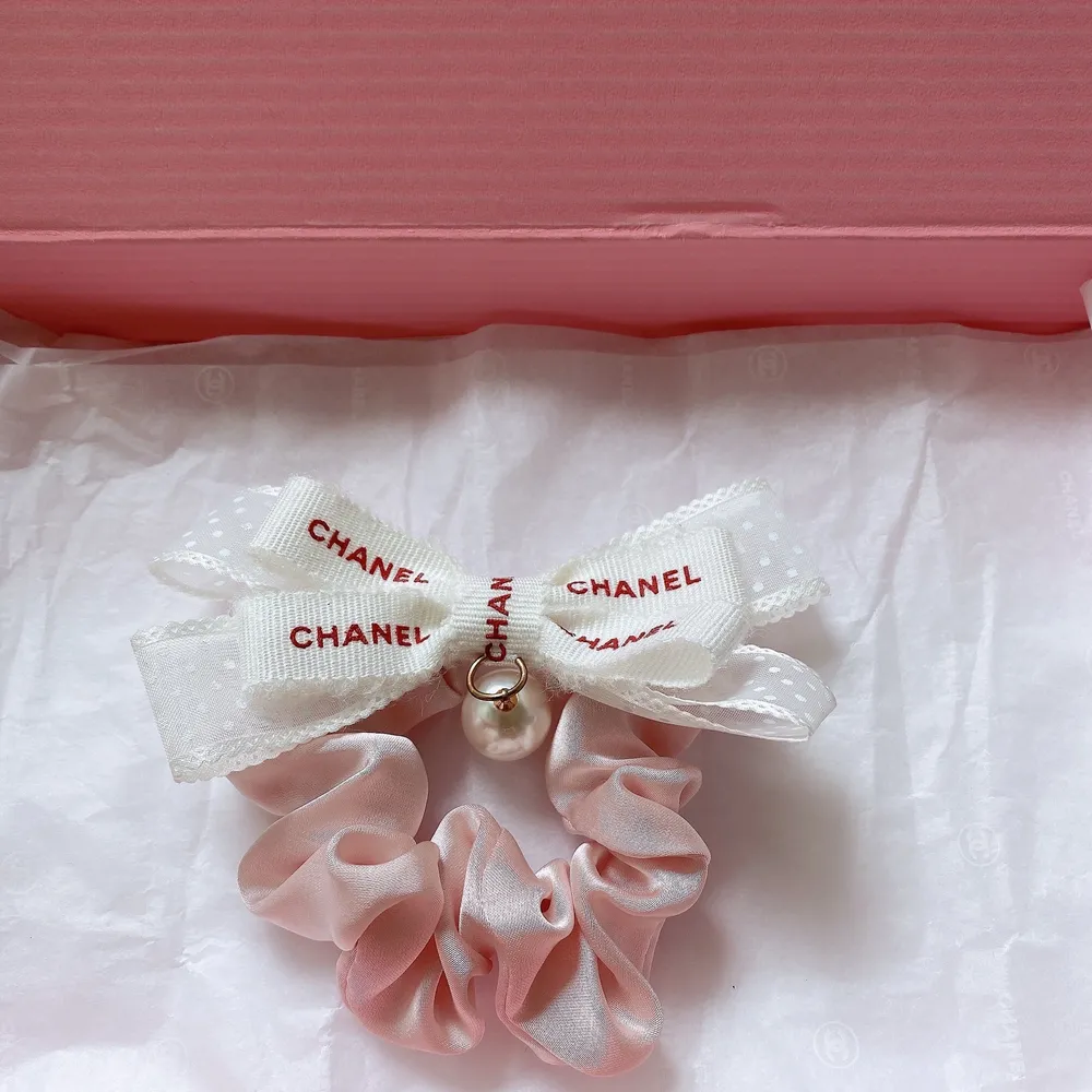Väldigt söt hårsnodd med rosett i vit och rosa färg. Äkta Chanel band. Kolla gärna mina andra annonser för söta/ fina små saker.  Frakten kostar 13kr . Accessoarer.