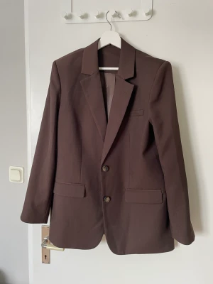 Kavaj från NAKD - Supersnygg brun kavaj från Nakd som tyvärr inte kommer till användning av mig. Står ingen storlek, men skulle gissa på 36/38 (lite oversize) Fint skick! Nypris 848kr, säljer för 350kr.  