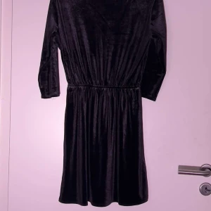 Sammets långärmad klänning  - Sammets klänning med långa ärmar och med v-uringning knappt andvänd