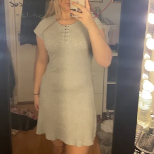 Grå klänning  - En basic grå klänning med snörning vid bysten, säljer då den inte kommer till användning 