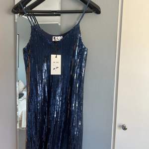 Säljer en blå glittrig klänning från Linn Ahlborg x NA-KD i storlek 32, stor i storleken. Aldrig använd med lapp kvar. Köpt för kanske 2 år sedan. 