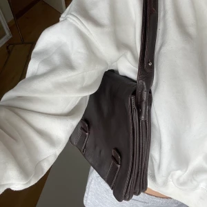 Brun handväska - Brun handväska med ljusa sömmar😍 bandet kan justeras från kort till långt. Massa fickor inuti. Säljer endast pga har en liknande hemma. Skriv för fler bilder💕