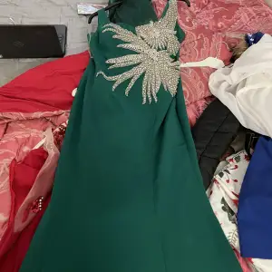 Lång grön klänning som har använts få gånger och har en sjal