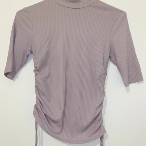 Topp  - En ljus lila färg, väldigt skön och mjuk att ha på sig och är ganska varm av sig, är justerbar med snörena som ni kan se. Skick 10/10 den är inte sönder och har knappt haft på mig den ksk 1 gång. Kostade 200 i zalando och Lindex. Prisskillnad 125 kr🤩