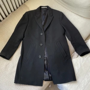 Yllerock - Enkelknäppt herrock i ull från Tiger of Sweden. 70% ull, 30% polyester. Nypris 5999kr. Bra skick.