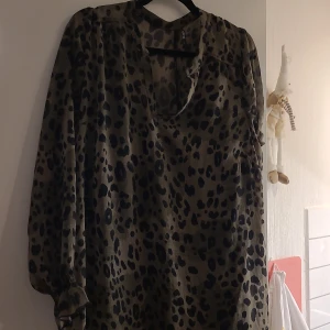 Klänning - Klänning med svart underklänning, skärp i midjan 