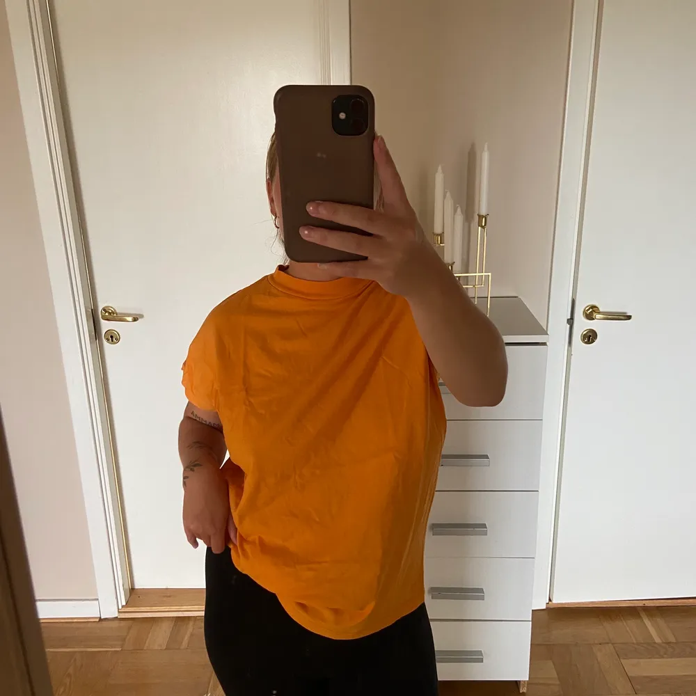 Orange t-shirt från WEEKDAY med lite högre krage. T-shirts.