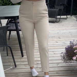 Beiga kostymbyxor strl 36 - Beiga ankellånga kostymbyxor från Ginatricot strl 36.