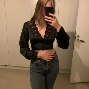 Svart topp - Svart ”silk-topp” med spets. 
