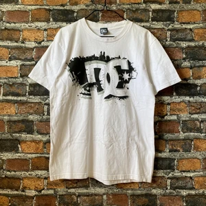 Vit DC T-shirt - En riktigt snygg dc tröja i vit feg med tryck på. I topp skick, inga fläckar eller slitage. Storleken är M-L. För mått eller fler bilder kontakta mig 🙌 Frakt sker via PostNord spårbart 51 kr 📦