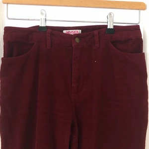 Indiska Manchester Byxor St 38 - Byxor i manchester från Indiska. Storlek 38 men passar antagligen storlek 36 också. Är i färgen burgundy och säljer ett par identiska byxor i senapsgult. Två raka fickor på baksidan och är utsvängda i avslutet på byxorna. Lite vintage känsla! 