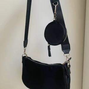 Väska - Svart väska oanvänd går att ta av bandet och göra till en hand väska med hjälp av ett mindre band i. 