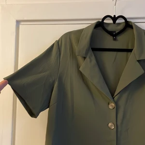 Grön topp - Grön blus från Vero Moda. Materialet kommer inte riktigt fram på bilden. Materialet syns bäst på ärmen på bild 1. Storlek L. Frakt tillkommer