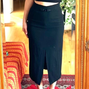 Svart pennkjol  - Svart ull kjol hög i midjan. 