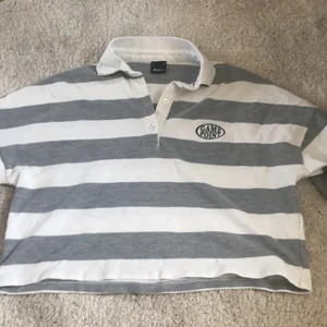 randig crop top från gina tricot  - randig kort långärmad tröja från gina tricot. alla knappar kvar, i bra skick. använd ca 5 gånger. en extra knapp. orginalpris 149 kr. 