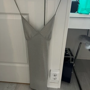 Glittrig Klänning - Fin grå/glittrig klänning, använd en gång så i nyskick och sälj pga att den inte kommer till användning mer! säljaren står för frakten!