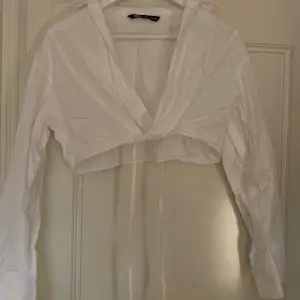 Croppad skjorta med knytning från Zara. Endast använd en gång.  Köparen står för frakten.