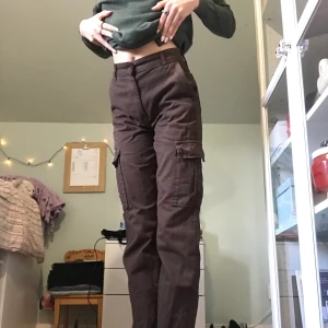Bruna cargo jeans - Dessa bruna cargo byxor köpte jag på plick men de va för korta på mig :,( vilket är varför jag säljer dem. Från märket STR. Det står stl 36, men midjemåttet tvärsöver är 34cm (därav skriver jag 34 som stl), innebenslängden 77cm. Inga defekter 🤎