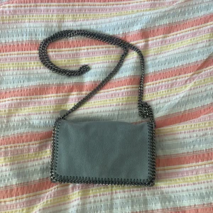 Stella McCartney väska  - Laggt ut tidigare, men inte sålt.   Säljer min fina Stella McCartney väska i modellen Falabella crossbody bag. Den har perfekta ljusblå färg. Använts under perioder men är fortfarande i mycket fint skick. Man får plats med förvånansvärt mycket i!  Äkta  