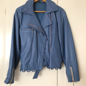 Vintage läderjacka  - Klarblå läderjacka med detaljer.  Storlek S Köptes i Paris och har tyvärr ett sträck på ena armen men ingen man tänker på. 